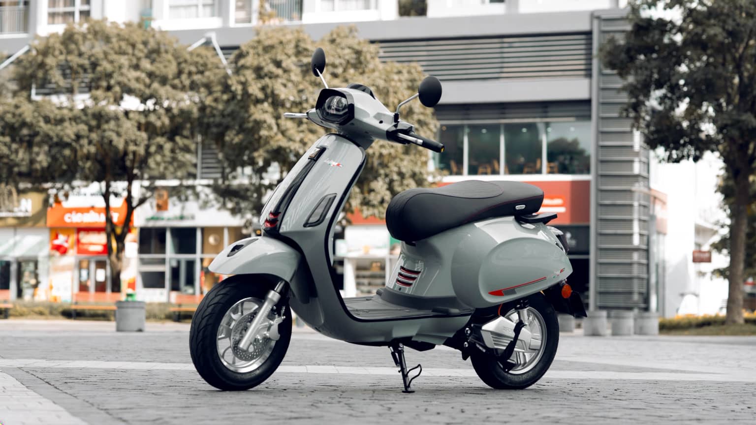 Xe điện Before All Latina VI 2.0 màu bạc đỗ trên vỉa hè lát đá ở khu phố