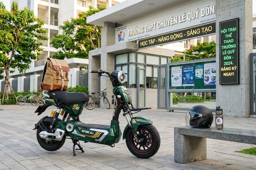 Xe đạp điện Before All S6 màu xanh rêu đỗ trước cổng Trường THPT chuyên Lê Quý Đôn, cạnh mũ bảo hiểm